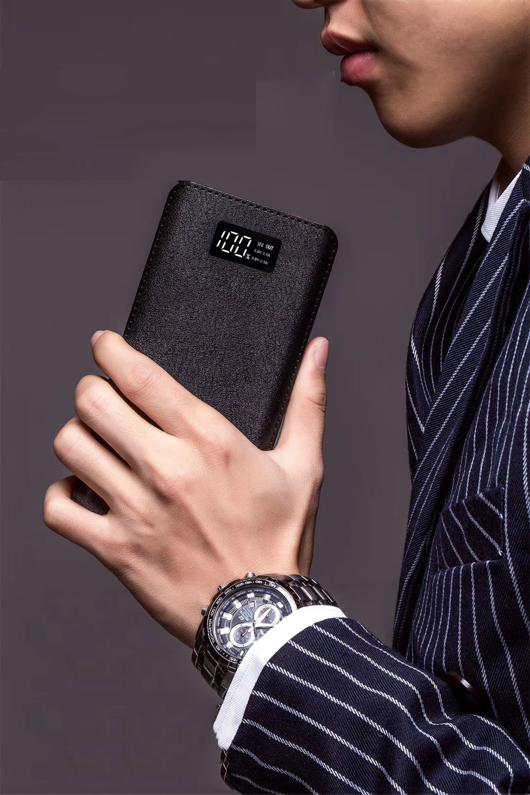 Person holding a black power bank with digital battery display