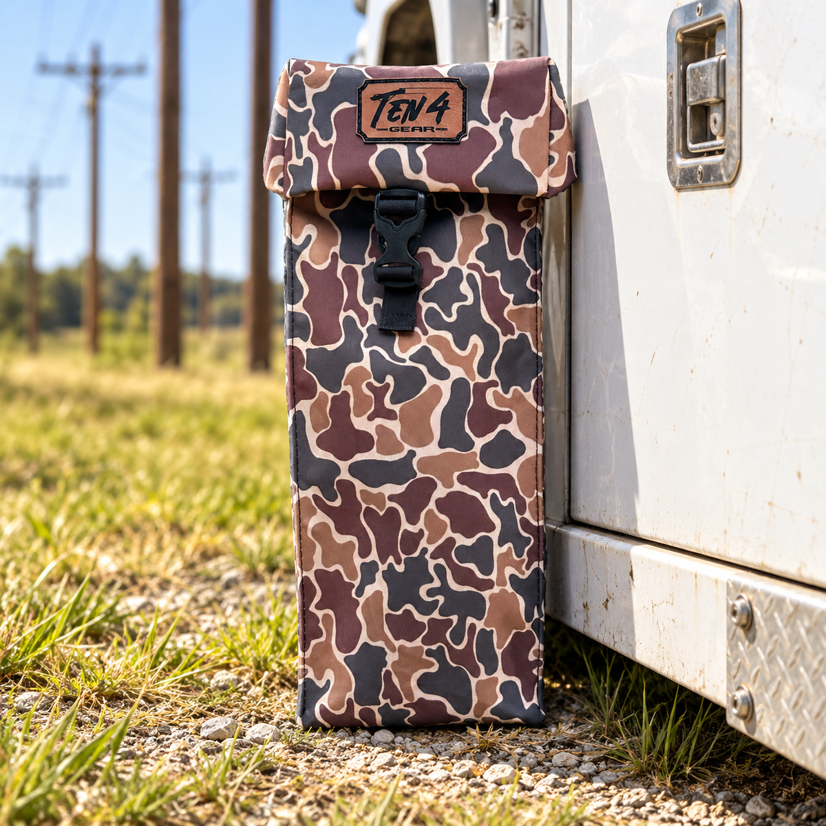 Duck Camo Classic bag with formed buckle lid beside a utility truck