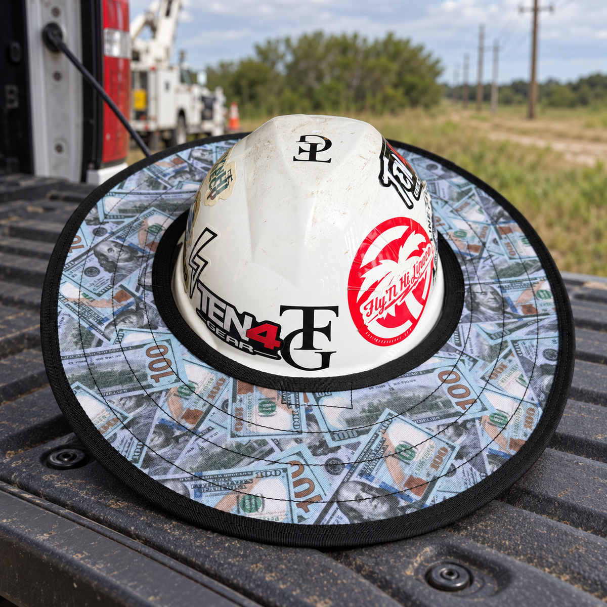 Blue Strips sunshade on a white hard hat resting on a truck tailgate at a rural utility worksite