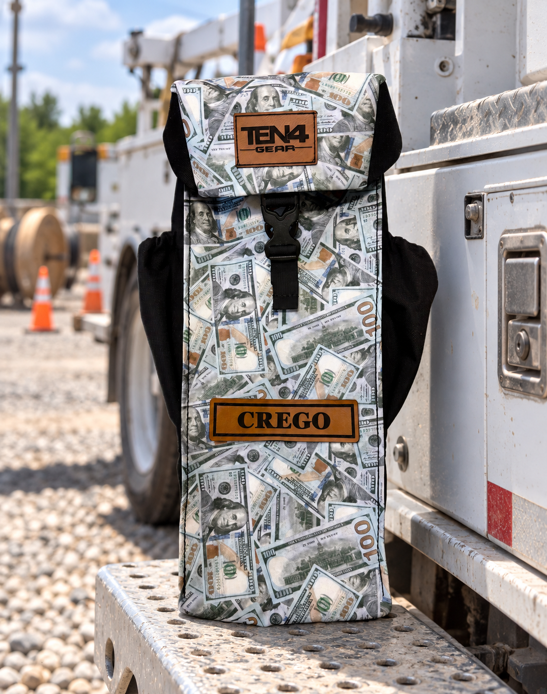 Blue Strips money-print Utility bag with formed buckle lid and two black side pockets — original product photo; background edited to an outdoor utility jobsite.