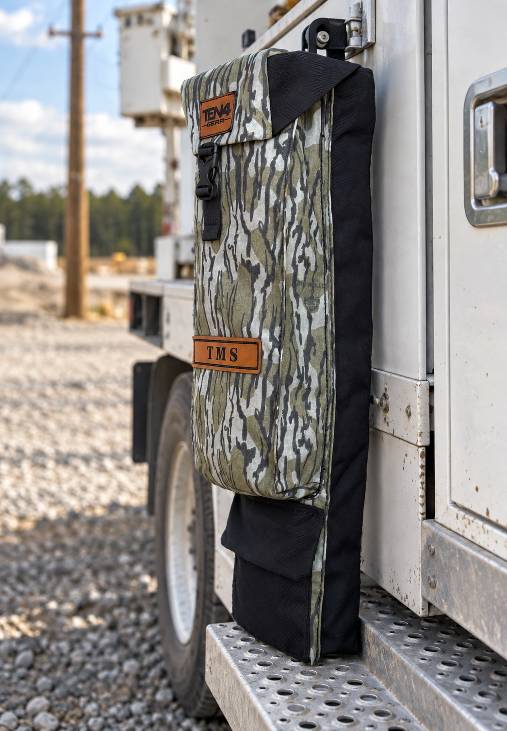 Bottomland 29-inch Classic bag with formed buckle lid and extra bottom pocket — original product photo; background edited to an outdoor utility jobsite.