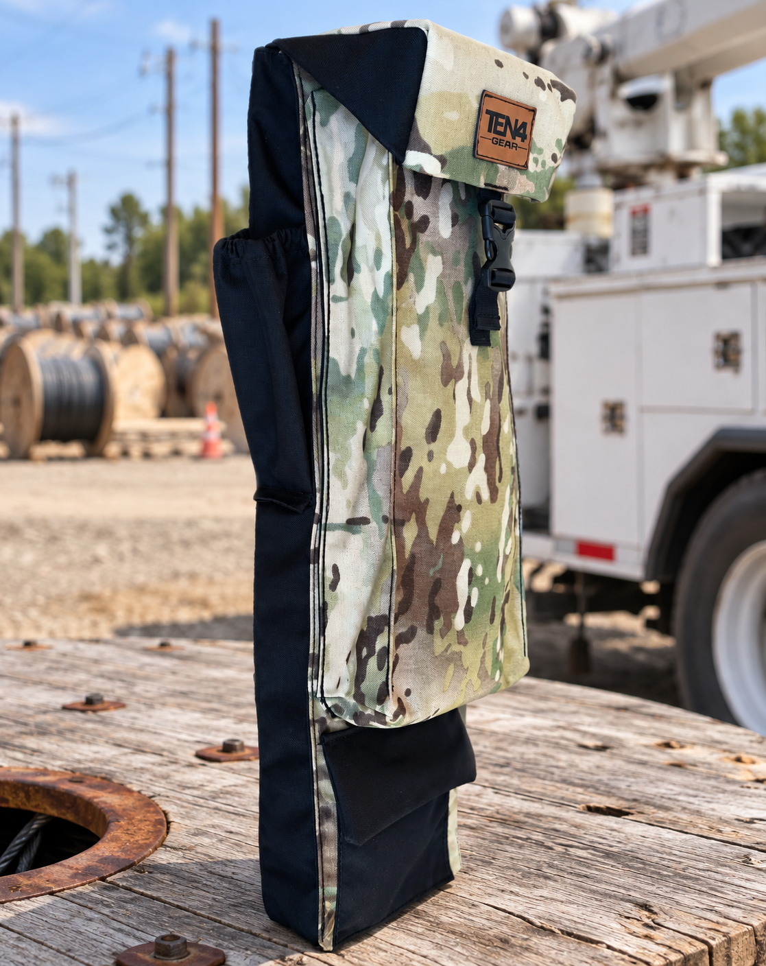 Defender 29-inch Utility bag with formed buckle lid, side pockets and extra bottom pocket — original product photo; background edited to an outdoor utility jobsite.