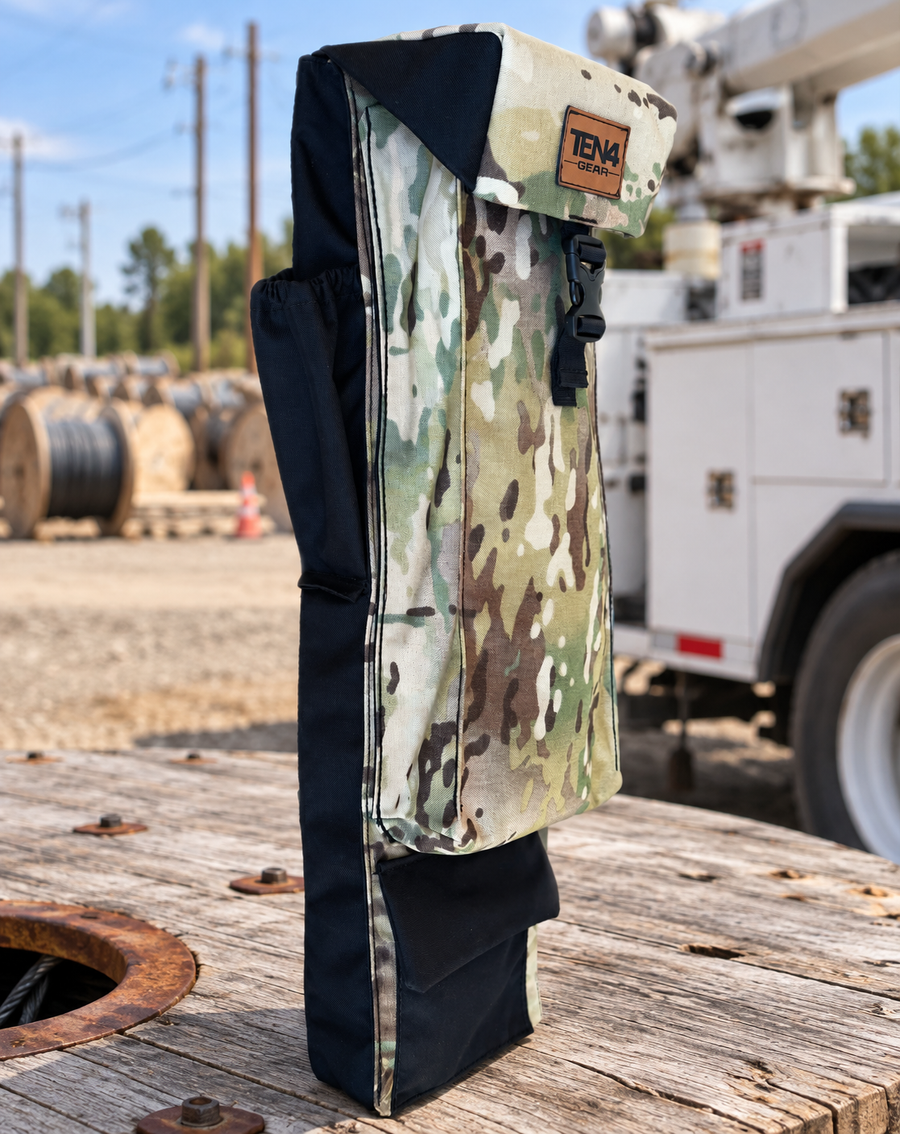 Defender 29-inch Utility bag with formed buckle lid, side pockets and extra bottom pocket — original product photo; background edited to an outdoor utility jobsite.
