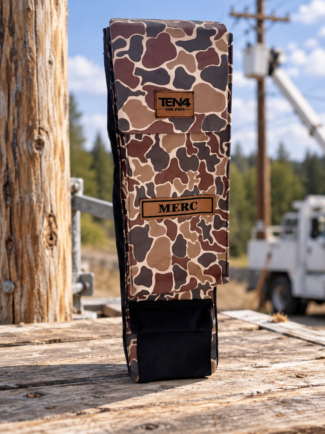 Duck Camo 29-inch Classic bag with flat Velcro flap and extra bottom pocket — original product photo; background edited to an outdoor utility jobsite.