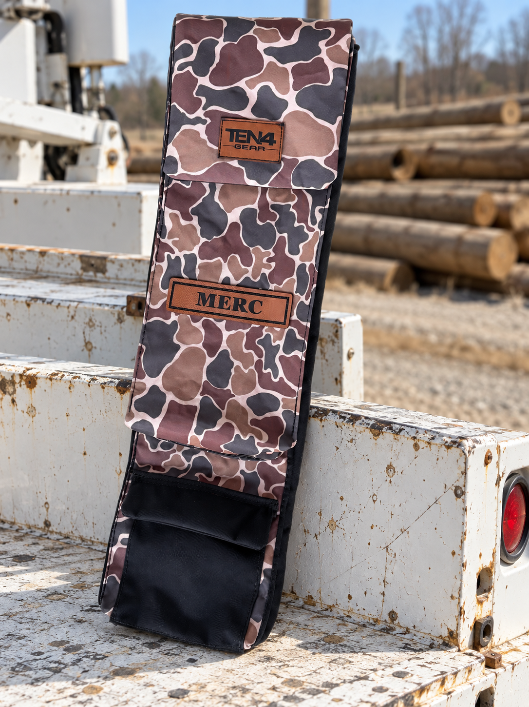 Duck Camo 29-inch Classic bag with flat Velcro flap and bottom-pocket detail — original product photo; background edited to an outdoor utility jobsite.