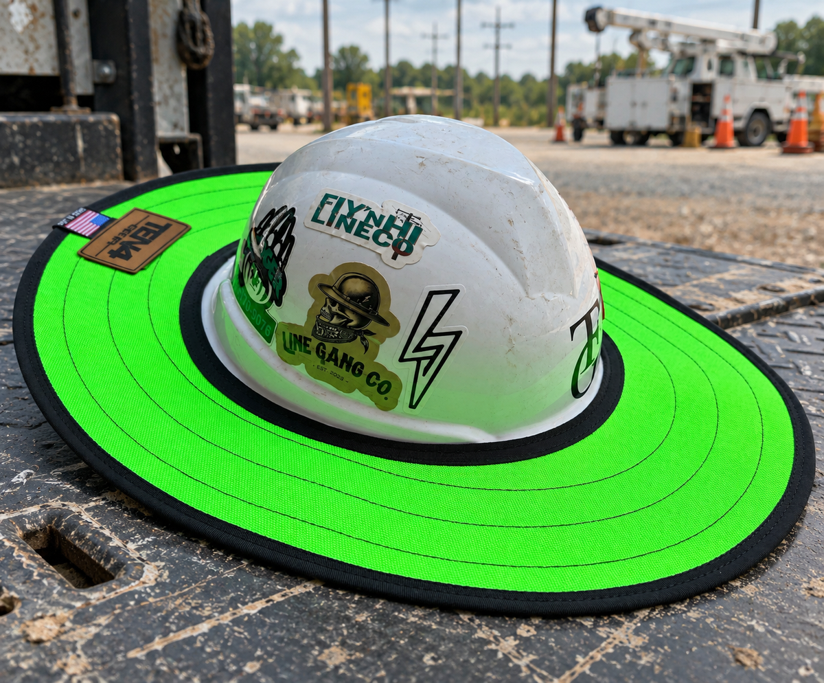 Electric Lime hard hat sunshade with current rear TEN4 patch on a utility truck at a linework site