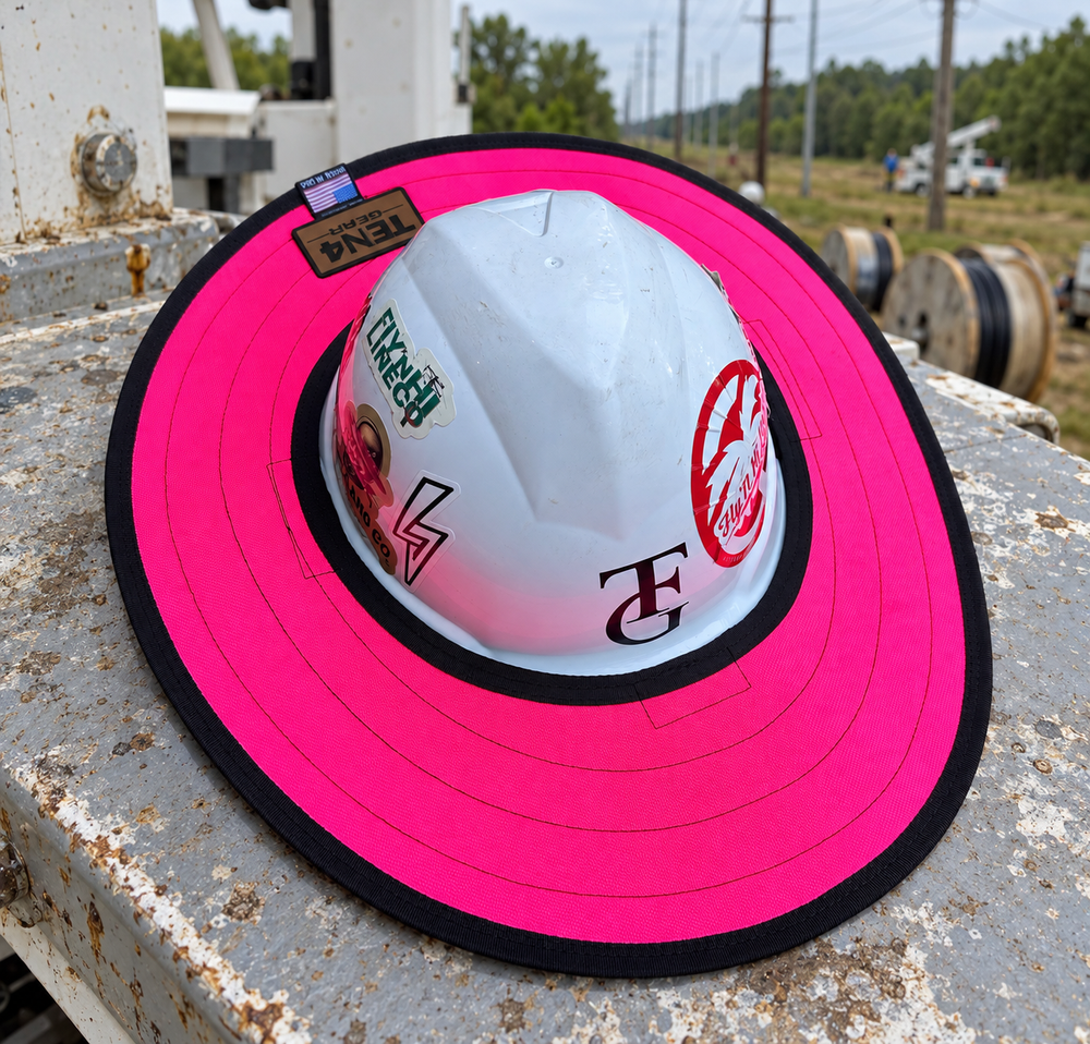 Electric Pink hard hat sunshade with current rear TEN4 patch on a utility truck at a linework site