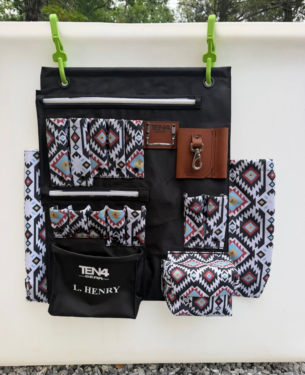 Original daylight photo of a compact TEN4 G-Board in Tomahawk pattern with L. Henry personalization, showing pocket layout and both unlit LED strips. Tools and mounting hooks not included.