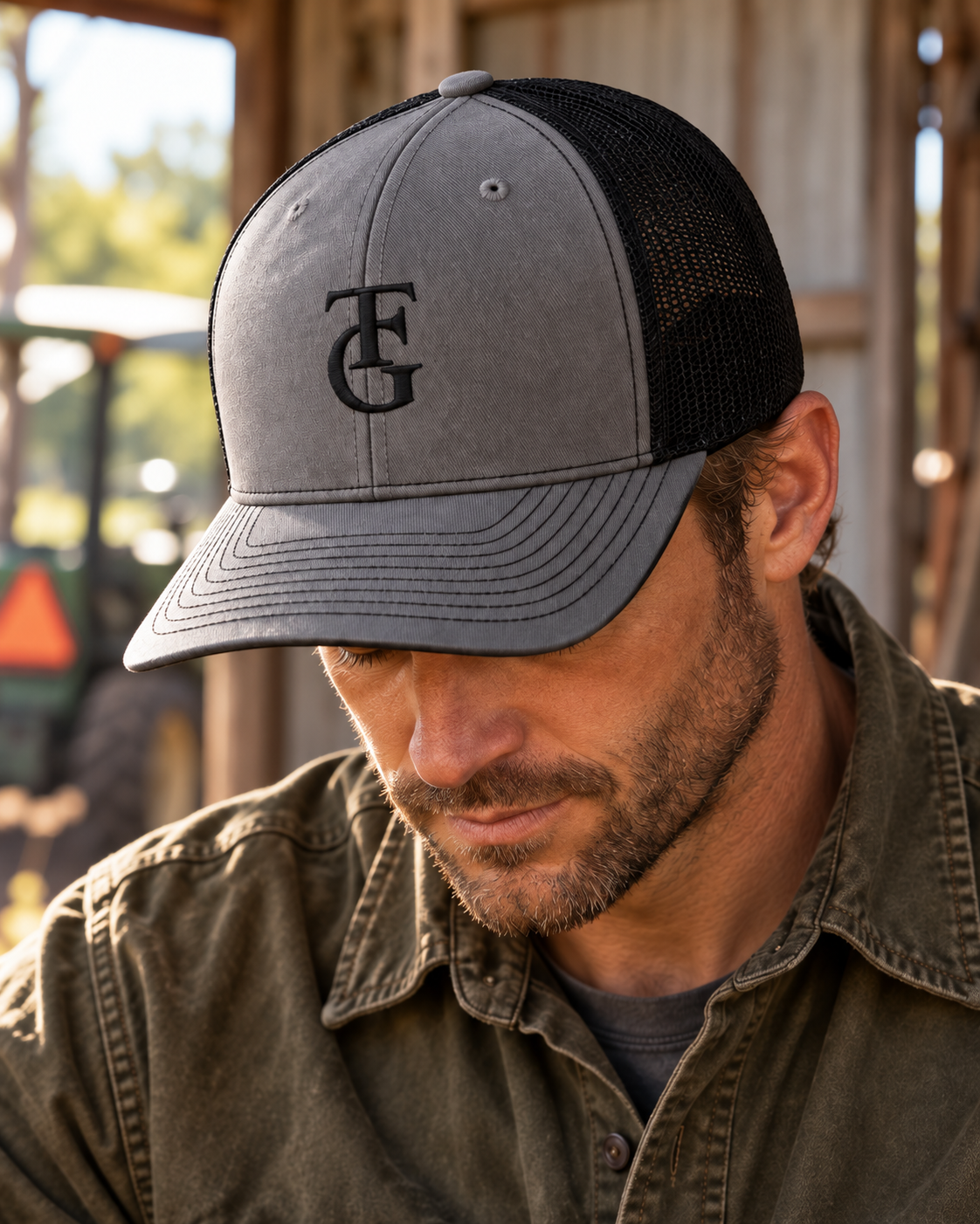 Close-up of charcoal and black TEN4 TFG Symbol Trucker Hat with black embroidery on a man looking down