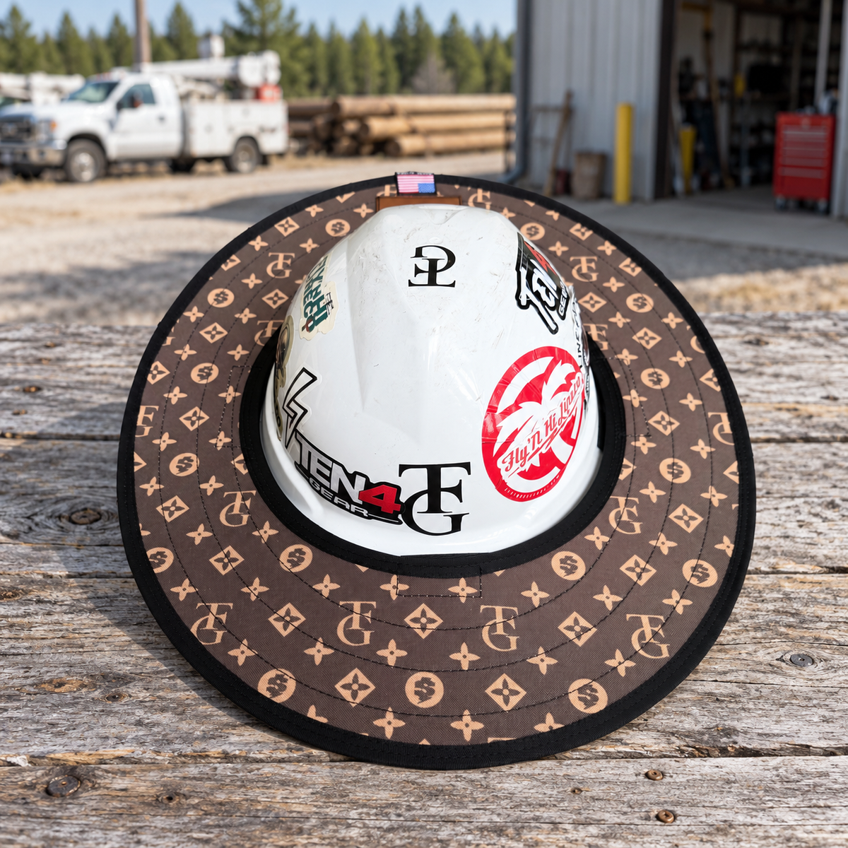 TG Brown sunshade on a white hard hat resting on a rustic workbench beside a utility workshop