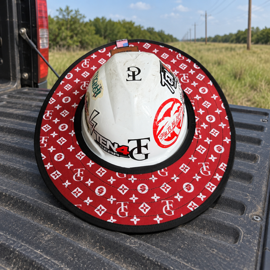 TG Red sunshade on a white hard hat resting on a pickup tailgate at a rural utility worksite