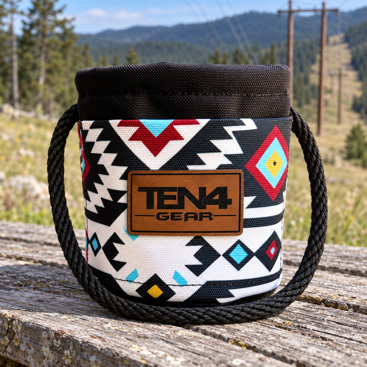 Tomahawk Grunt Sack with current TEN4 patch on an outdoor bench beside a mountain powerline